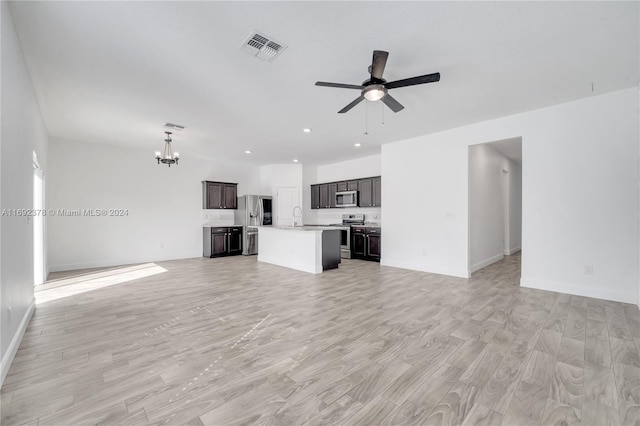 unfurnished living room with sink, ceiling fan with notable chandelier, and light hardwood / wood-style flooring