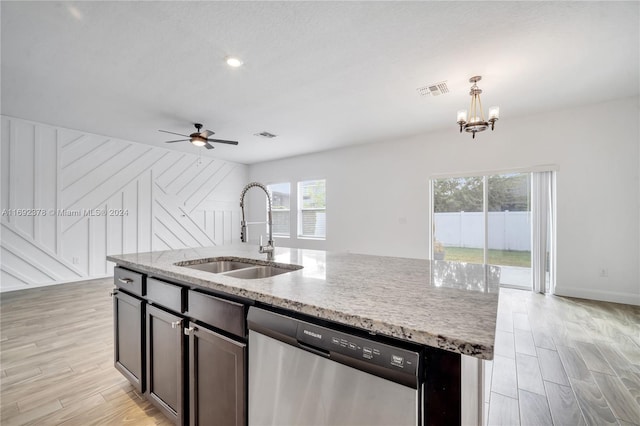 kitchen with dishwasher, sink, a kitchen island with sink, light wood-type flooring, and decorative light fixtures