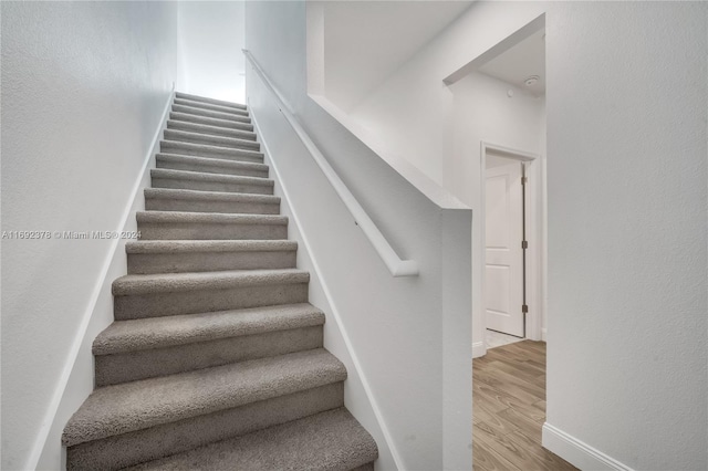 stairway with hardwood / wood-style flooring