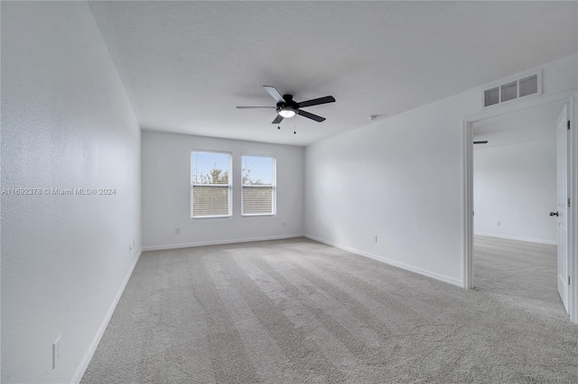 spare room featuring light colored carpet and ceiling fan