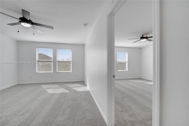 carpeted spare room with plenty of natural light and ceiling fan