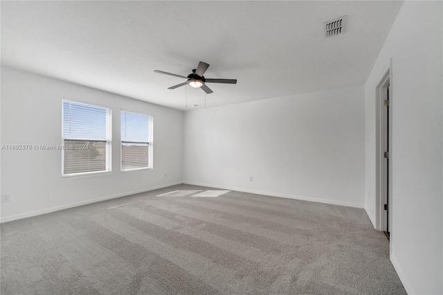 carpeted spare room featuring ceiling fan