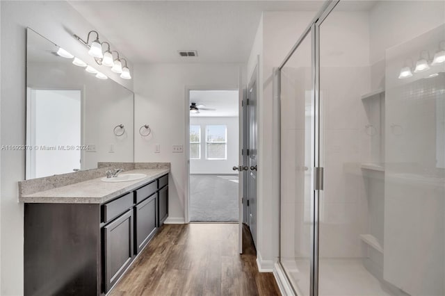 bathroom featuring hardwood / wood-style floors, vanity, ceiling fan, and a shower with door