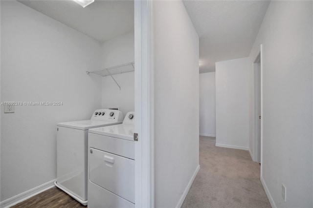 laundry area featuring washing machine and dryer and light colored carpet