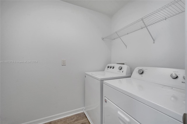 laundry area with washing machine and dryer and hardwood / wood-style flooring