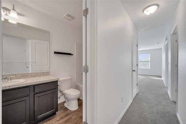 full bathroom with washtub / shower combination, wood-type flooring, vanity, and toilet