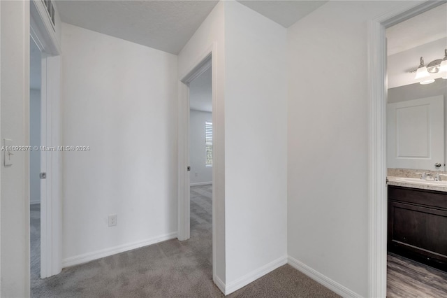 hallway with sink and light carpet