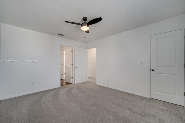 unfurnished room with light colored carpet and ceiling fan