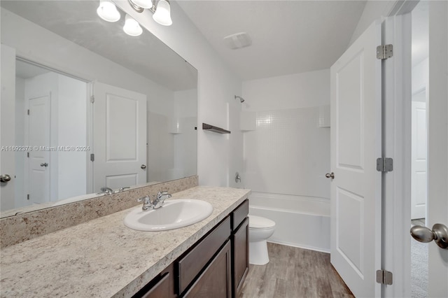 full bathroom featuring toilet, tiled shower / bath combo, vanity, and wood-type flooring