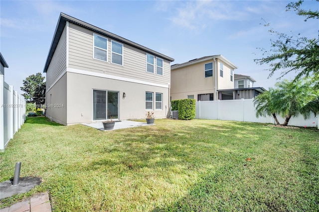 rear view of property featuring a patio area, central AC, and a yard