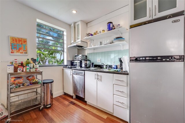 420 15th St Unit 107, Miami Beach, FL 33139 - kitchen with appliances with stainless steel finishes, white cabinets, light wood-style floors, dark countertops, and recessed lighting