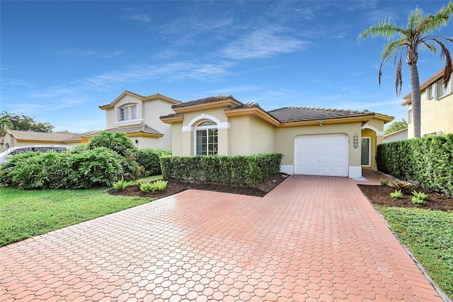 mediterranean / spanish home featuring a garage and a front lawn