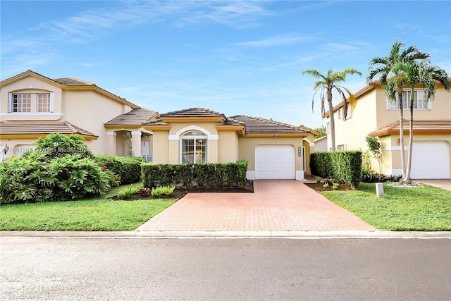 mediterranean / spanish house featuring a front yard and a garage