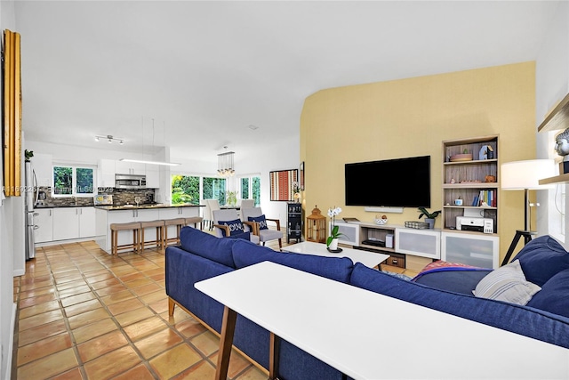 tiled living room featuring an inviting chandelier