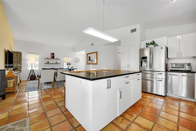 kitchen with a center island, lofted ceiling, white cabinets, light tile patterned floors, and stainless steel appliances