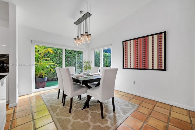 dining area with light tile patterned floors, lofted ceiling, and an inviting chandelier