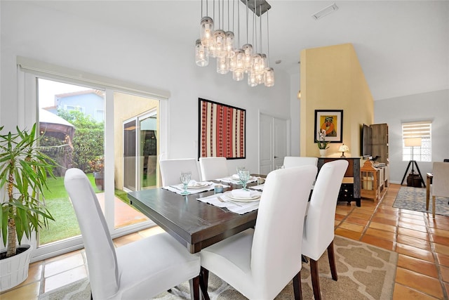 tiled dining area featuring a high ceiling and a notable chandelier