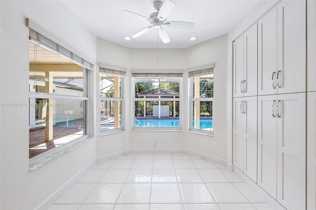 unfurnished sunroom with ceiling fan