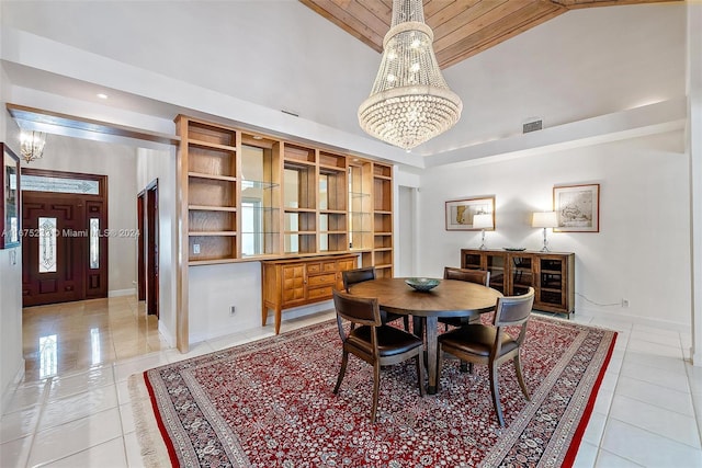 tiled dining area featuring high vaulted ceiling and a notable chandelier