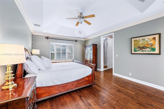 bedroom featuring ceiling fan, a raised ceiling, ornamental molding, and dark wood-type flooring