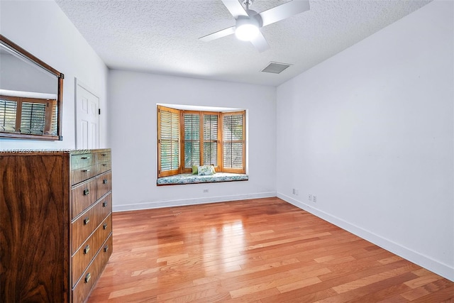 bedroom featuring a textured ceiling, light wood-type flooring, and ceiling fan