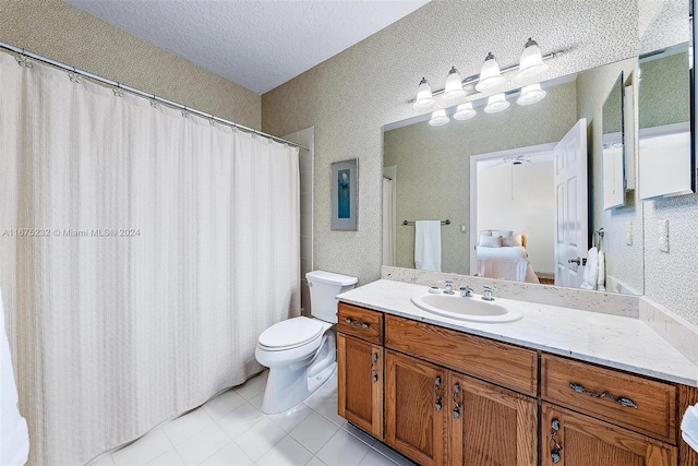 bathroom with tile patterned flooring, vanity, toilet, and a textured ceiling