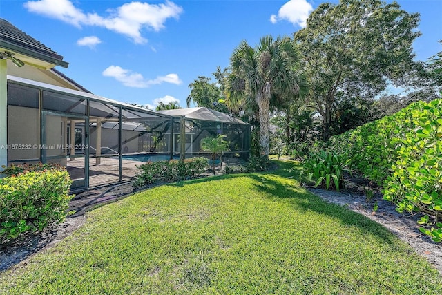 view of yard featuring glass enclosure and a patio