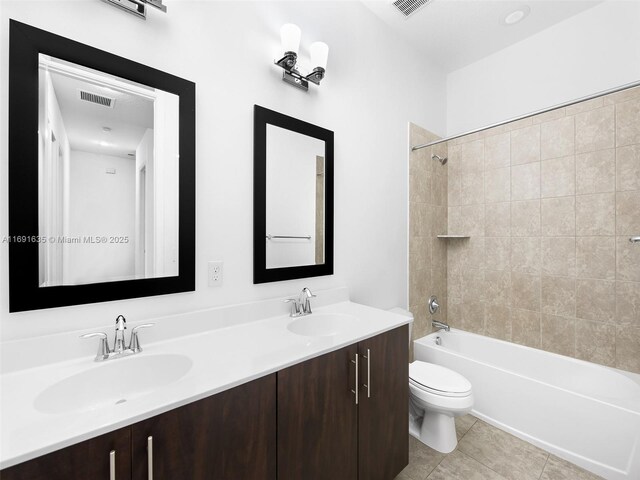 full bathroom with tiled shower / bath, vanity, toilet, and tile patterned flooring