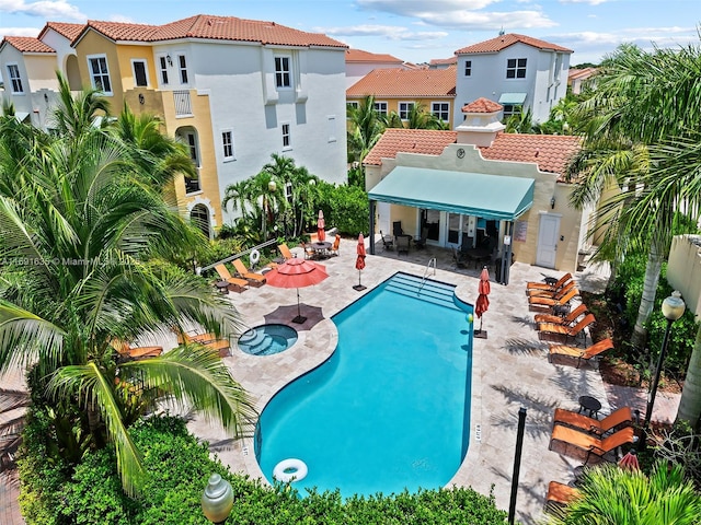 view of pool featuring a patio area and an in ground hot tub