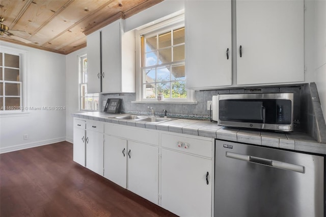 kitchen featuring white cabinetry, appliances with stainless steel finishes, dark wood-type flooring, and tile counters