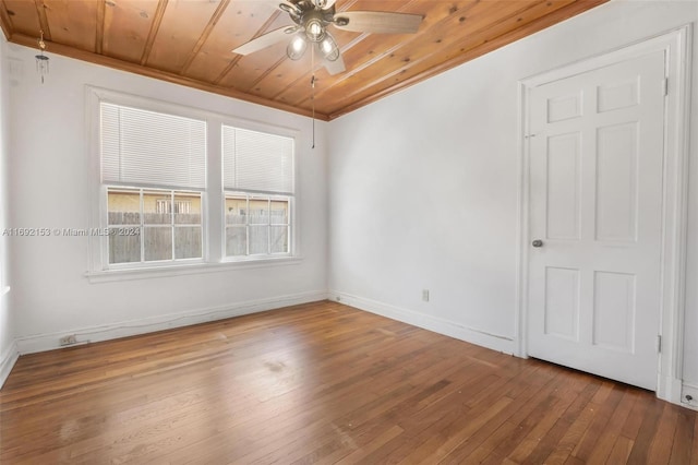 empty room featuring ceiling fan, wood-type flooring, wood ceiling, and crown molding