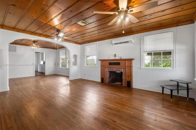 unfurnished living room with a brick fireplace, dark hardwood / wood-style flooring, a wall mounted AC, wooden ceiling, and ceiling fan