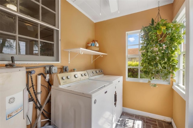 clothes washing area featuring water heater, washer and clothes dryer, and ornamental molding