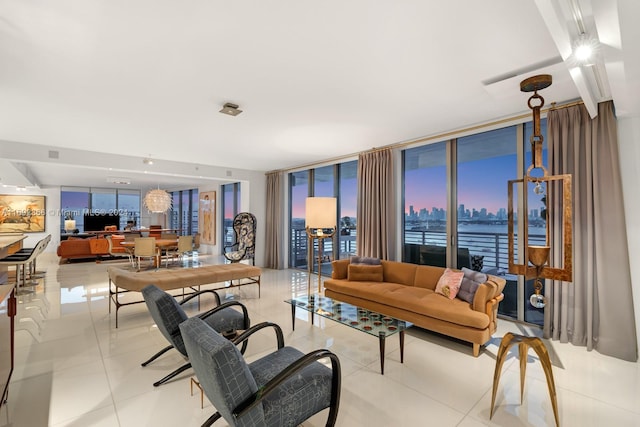 tiled living room featuring expansive windows and a water view