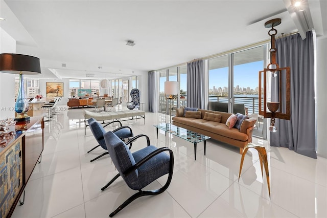 living area featuring a wall of windows, a water view, and light tile patterned flooring