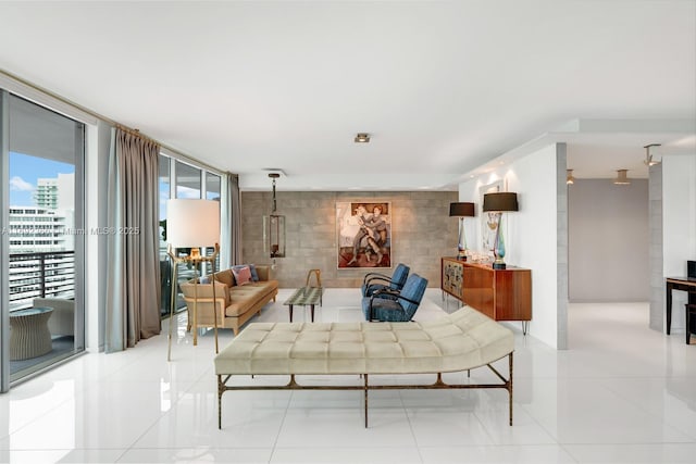 living room featuring a wall of windows and light tile patterned floors