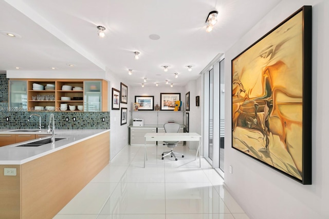 interior space featuring recessed lighting, baseboards, a sink, and light tile patterned flooring