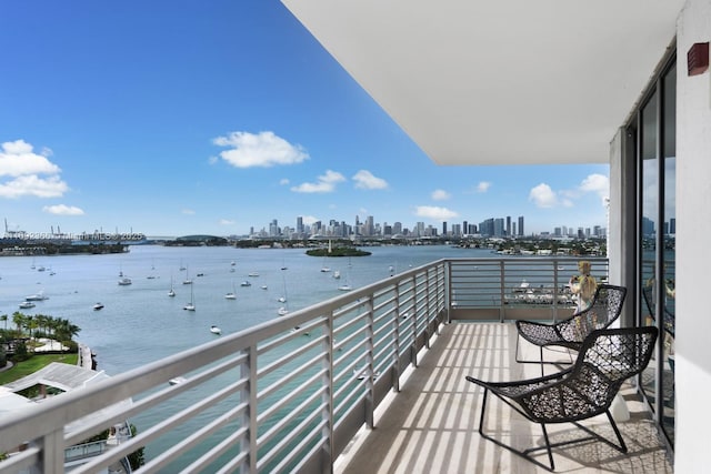 balcony with a water view and a view of city