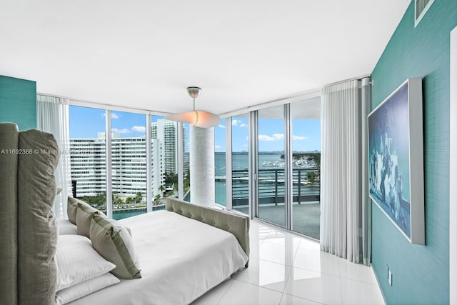 bedroom with a water view, access to exterior, a city view, and light tile patterned flooring