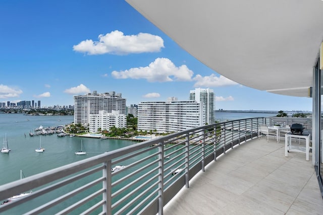 balcony featuring a water view and a view of city