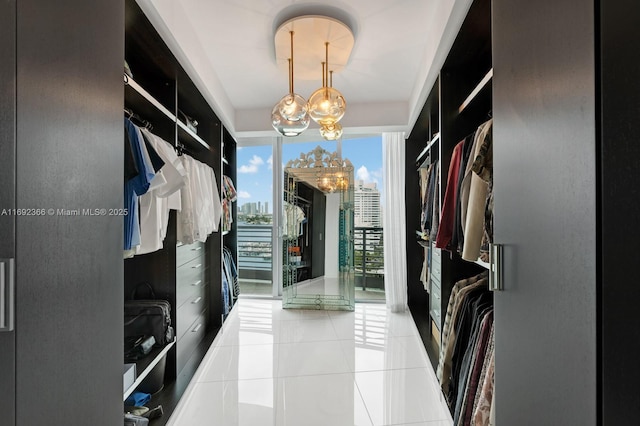 spacious closet with light tile patterned floors and a chandelier