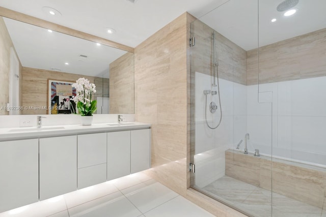 bathroom featuring double vanity, a sink, tile walls, and a shower stall