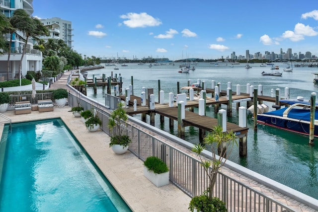 dock area with a water view, fence, a community pool, and a city view