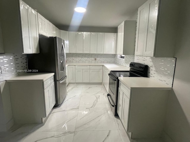 kitchen featuring white cabinets, appliances with stainless steel finishes, and backsplash