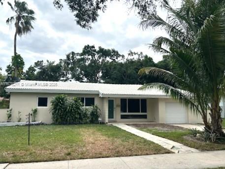 single story home with a garage, a front yard, concrete driveway, and stucco siding