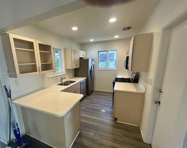 kitchen featuring a sink, dark wood-style floors, glass insert cabinets, stainless steel appliances, and visible vents