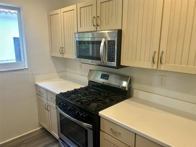 kitchen with dark wood finished floors, baseboards, light countertops, and stainless steel appliances