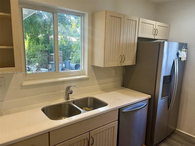 kitchen featuring light countertops, wood finished floors, a sink, and stainless steel appliances