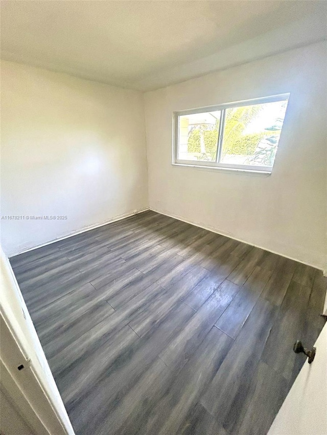 spare room with dark wood-type flooring