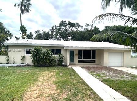 ranch-style house with a garage, concrete driveway, stucco siding, and a front lawn